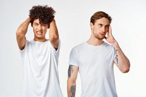 dos amigos en blanco camisetas sostener su cabezas emociones foto