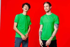 two men in green t-shirts are standing side by side communication emotions friendship photo