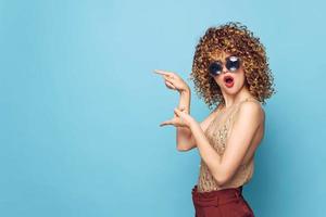 Charming model surprised look hand gestures red lips curly hair Copy Space photo