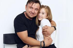 father hugs daughter family studio lifestyle close-up photo