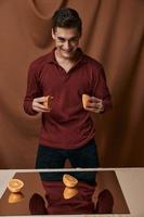 Man with oranges in his hands red shirt smile mirror on the table photo