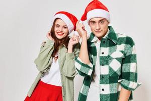 Happy woman in a Christmas hat and a man in a plaid shirt on a light background photo