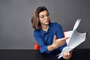 Business woman sits at a work table folder in hands Copy Space photo