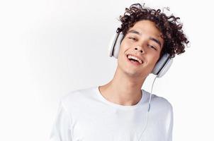 emocional hombre con Rizado pelo y en auriculares escucha a música ligero antecedentes foto