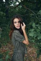 Woman in the forest attractive look in a green suit fresh air background summer photo