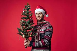 alegre hombre en un Papa Noel sombrero Navidad decoraciones fiesta nuevo año rojo antecedentes foto