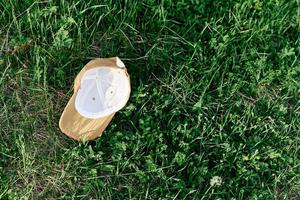 A yellow sports cap lies upside down on the green grass. Spring outdoor sports games photo