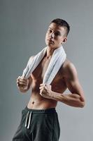 sporty man with towel on shoulders with pumped up torso cropped view posing photo