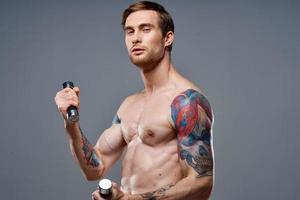 sexy atleta con bombeado arriba brazo músculos y salud vitaminas pesas modelo foto
