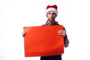 handsome man in New Year's clothes holding a banner holiday light background photo