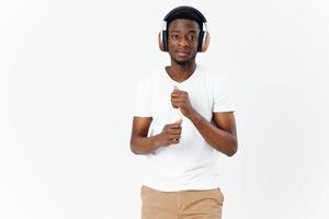 man in a white t-shirt with headphones listens to music light background photo