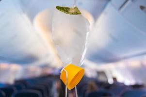 oxygen mask drop from the ceiling compartment on airplane photo