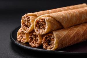 Delicious crispy wafer rolls with cream filling with nuts photo