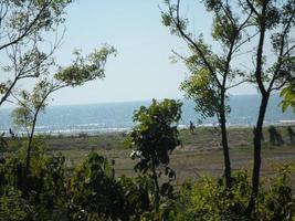 Photo of a sunny day view of a beautiful tropical beach and sea on a sunny day in Cox's Bazar, Bangladesh. Travel and Vacation.