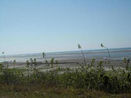 Photo of a sunny day view of a beautiful tropical beach and sea on a sunny day in Cox's Bazar, Bangladesh. Travel and Vacation.