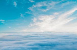 Blue sky with some clouds. View over the clouds.ummer blue sky cloud gradient light white background. Beauty clear cloudy in sunshine calm bright winter air bacground. Gloomy vivid cyan landscape in e photo