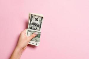 Top view of female hand holding a pack of one hundred dollar bills on colorful background. Wage and salary concept with empty space for your design photo