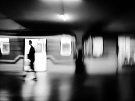 negro y blanco movimiento difuminar imagen de subterraneo con un tren y pasajeros foto
