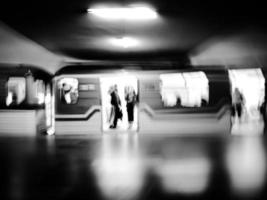 Black and white motion blur image of subway with a train and passengers. photo