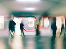 Lens blur image of a subway with moving human silhouettes and a train. Motion blur image of people. photo