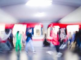 Lens blur image of a subway with moving human silhouettes and a train. Motion blur image of people. photo