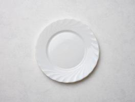 Empty white plate on white background, top view photo