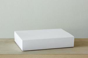 blank white cardboard package box mockup on wooden table photo
