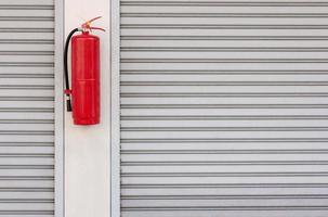 Fire extinguisher on the shutter door at home photo