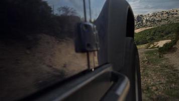 Disparo desde un cámara adjunto a el lado de un apagado la carretera caravana conducción en áspero pistas en cerdeña, Italia video