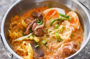 curry bone soup - bone noodle soup pork with boiled eggs in hot pot, Thai food tom yum hot and sour soup photo