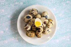 boiled eggs food, quail eggs on white plate, breakfast eggs with fresh quail eggs on table background photo