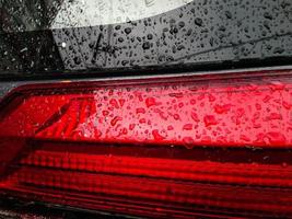 A red tail light with water droplets on it. photo