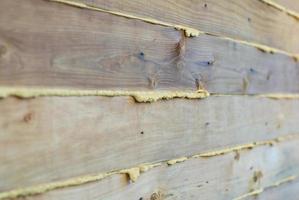 Seams of wooden house wall filled with polyurethane foam photo