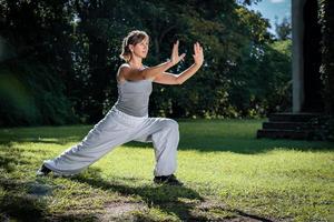 lado retrato de un mujer haciendo Tai chi ejercicio en natural ambiente. foto