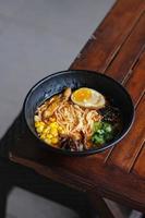 japanese ramen noodle with egg and vegetables in black bowl photo