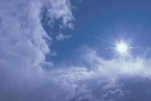 natural sun shines over clouds in deep blue stormy sky photo