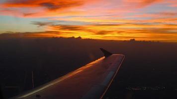 avión vuelo. ala de un avión volador encima el nubes con puesta de sol cielo. ver desde el ventana de el avión. de viaje por aire video