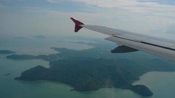 The plane flies over the ocean. View of the sea and islands from the airplane window. Tourist flight arrives on the island video