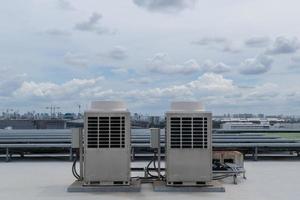 aire acondicionador unidades hvac en un techo de industrial edificio con azul cielo. foto