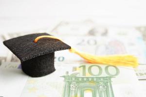Graduation gap hat on Euro and US dollar banknotes money, Education study fee learning teach concept. photo