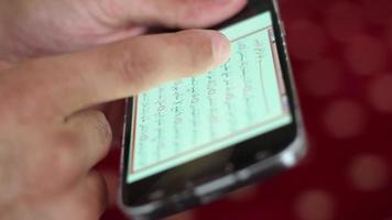 adolescentes lendo a Alcorão em uma Smartphone tela, muçulmano pessoas lendo a religioso livro do islamismo, e árabe alfabeto dentro Alcorão video