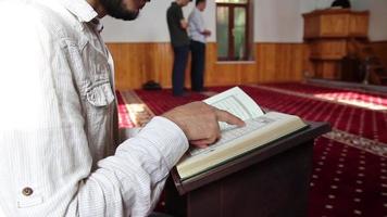 jung Mann lesen das Koran Stehen auf ein Tabelle im das Moschee, das Bild von jung Menschen beten im das Moschee, Anbetung zu Gott video