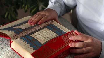 le image de le ouvert et brodé page de le coran permanent sur le tableau, le image de une religieux livre avec le arabe alphabet video