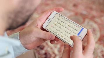 musulmán leyendo Corán con teléfono video