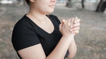 An adult whose hand is prayed on the dark background.Respect for belief in religion and God. front view. peace concept. photo