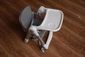 Baby high chair on a wood pattern floor. Baby equipment concept. photo