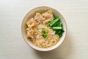egg noodles with pork wonton soup or pork dumplings soup and vegetable photo