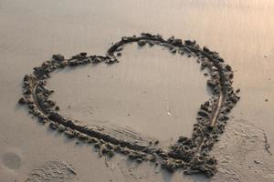 Heart shape on wet sand. Valentine's day background. Love concept. photo