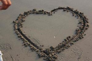 Heart shape on wet sand. Valentine's day background. Love concept. photo