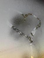 A love heart painted on a misted glass window background photo
